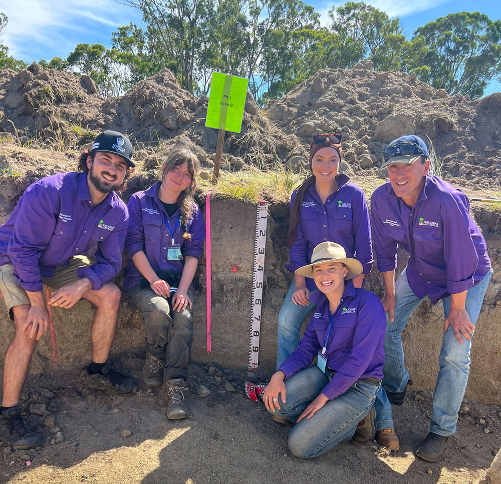 Ava Robertson and team members in front of soil measurement depth